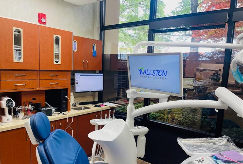 The image shows a dental office interior with a reception area, treatment chairs, and dental equipment.