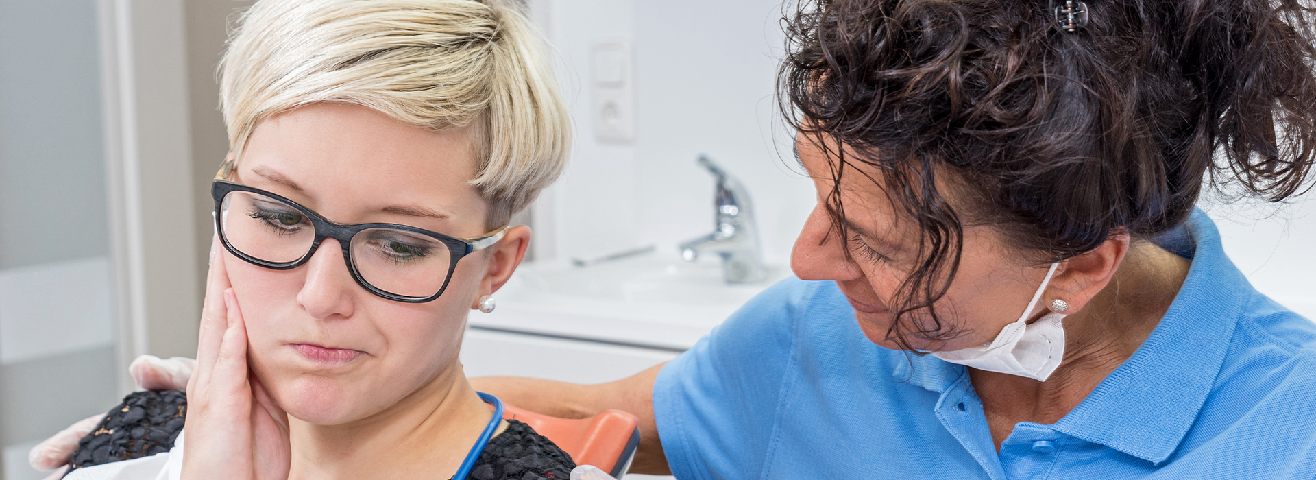 A dental hygienist assisting a patient during a dental appointment.