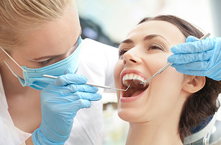 A dentist performing oral care on a patient s teeth.